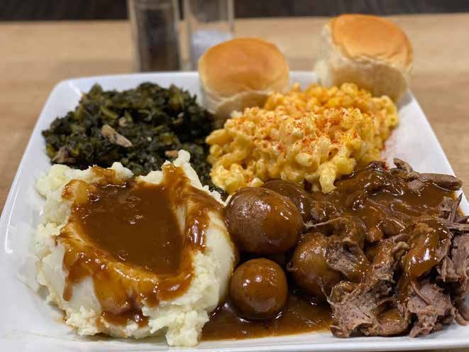 Soul food plate with roast beef, mashed potatoes, mac and cheese and greens