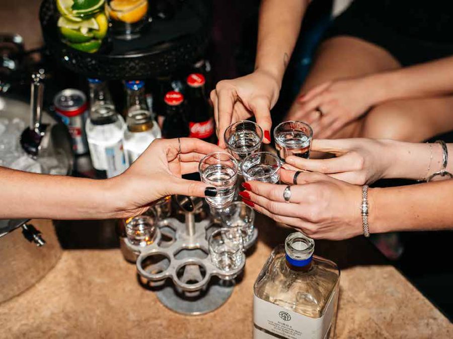 Friends raising shot glasses at the bar